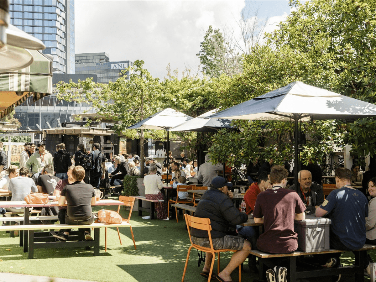 a group of people sitting at tables outside